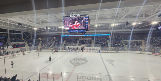Digital scoreboard displaying video during a hockey game at the Toscano Family Ice Forum