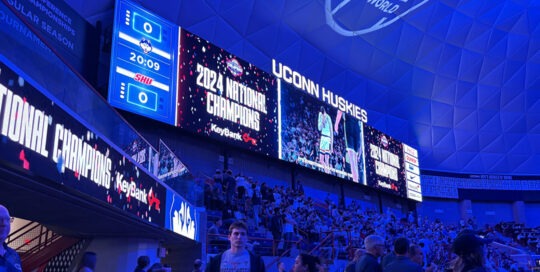 Digital scoreboard displaying graphics celebrating the 2024 National Champions at the UConn Huskies basketball game
